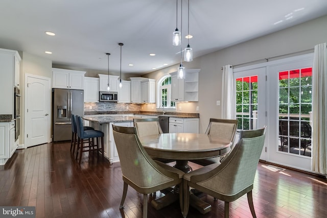 dining room featuring a healthy amount of sunlight, recessed lighting, and dark wood-style flooring