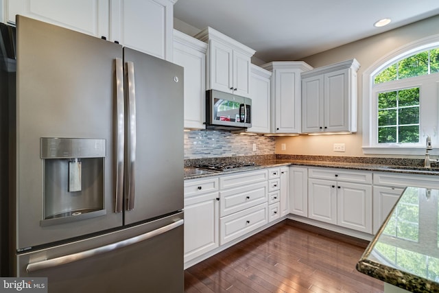 kitchen with a sink, stainless steel appliances, recessed lighting, and white cabinetry