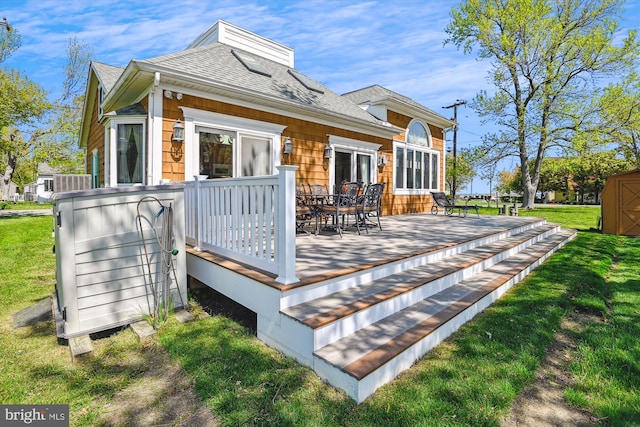 5211 Al Jones Dr, Shady Side, MD 20764 - rear view of property featuring an outdoor structure, a wooden deck, a shingled roof, a shed, and a yard