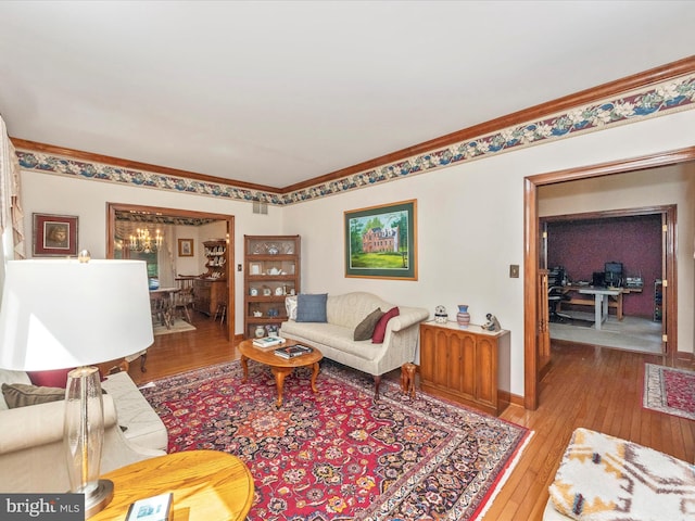 living area with wood-type flooring, ornamental molding, and baseboards