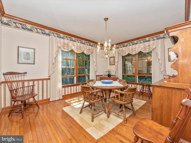 dining space with a notable chandelier, crown molding, baseboards, and light wood finished floors