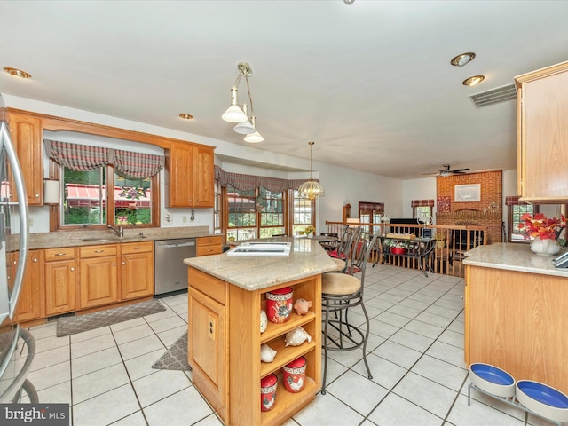 kitchen featuring light tile patterned floors, a sink, stainless steel appliances, and a center island