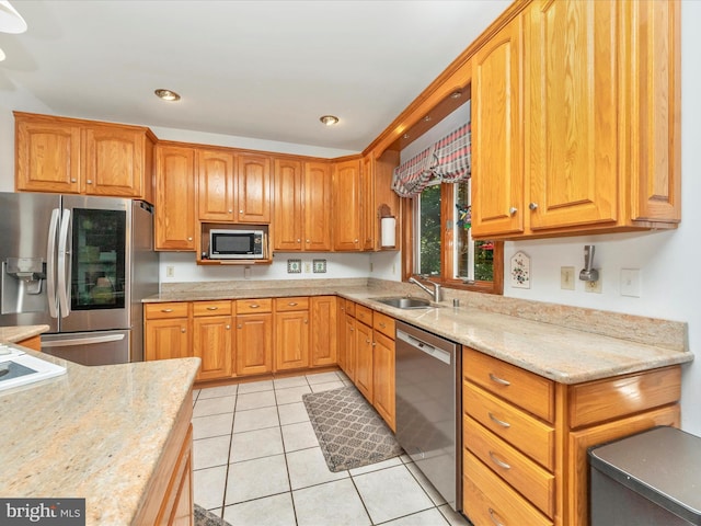 kitchen with recessed lighting, a sink, light tile patterned flooring, light stone countertops, and appliances with stainless steel finishes
