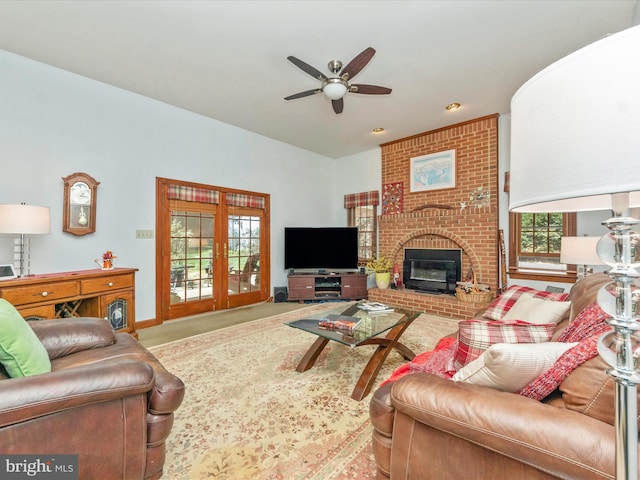 living room with a brick fireplace, baseboards, and ceiling fan