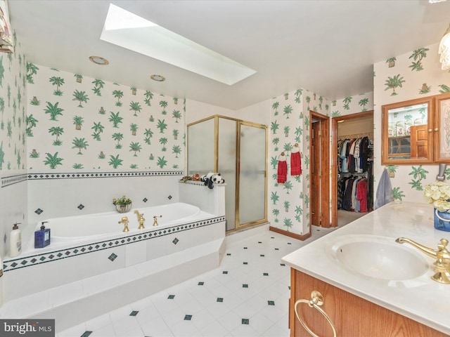 bathroom with a skylight, a shower stall, wallpapered walls, a sink, and a garden tub