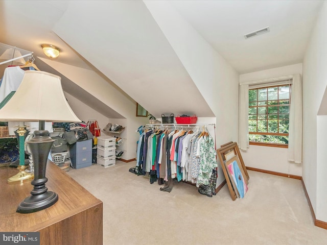 spacious closet featuring visible vents, carpet floors, and vaulted ceiling
