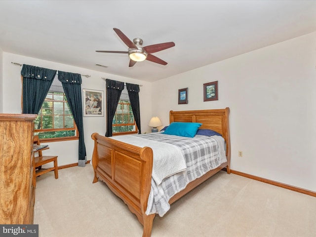 bedroom with baseboards, visible vents, and light carpet