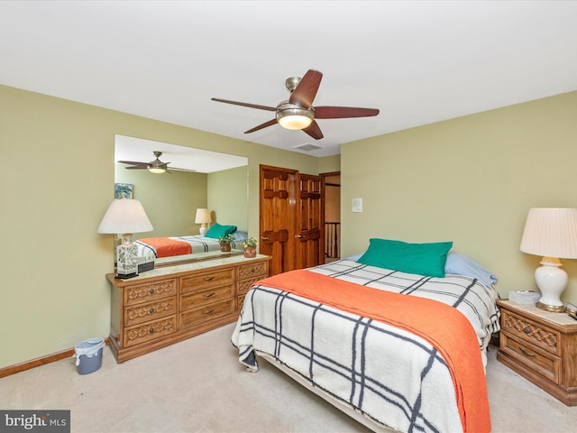 bedroom featuring light colored carpet, visible vents, baseboards, and a ceiling fan
