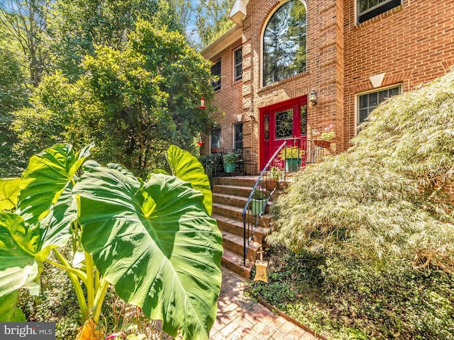 view of exterior entry featuring brick siding