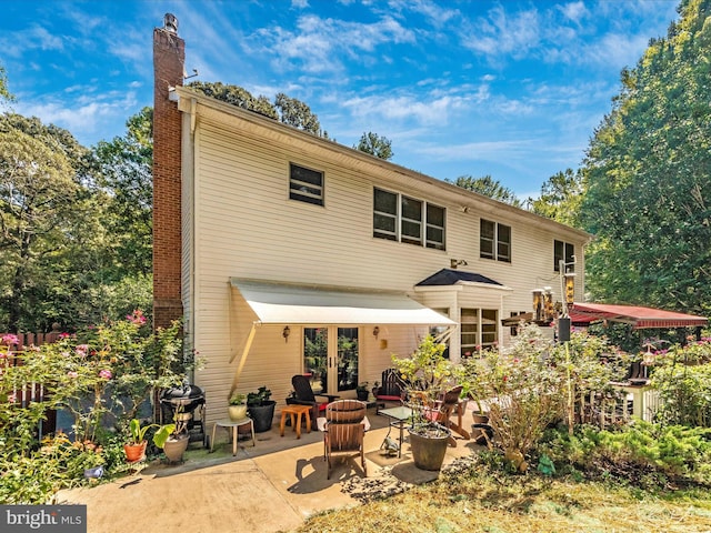 back of house featuring a chimney and a patio area