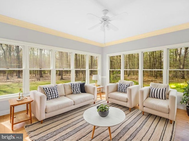 sunroom featuring a wealth of natural light, crown molding, and wood finished floors