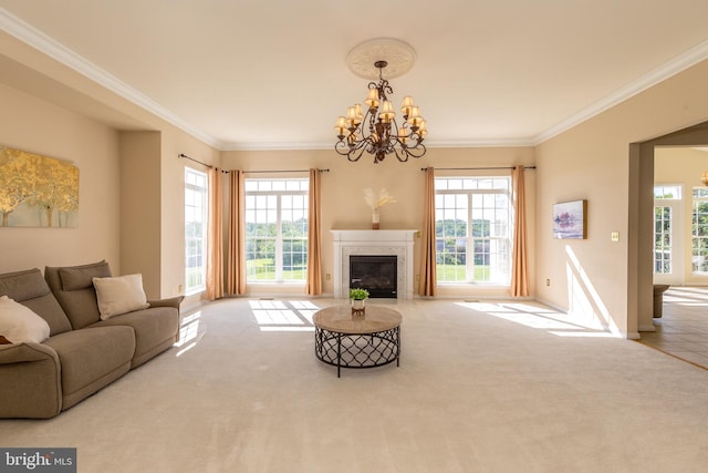 carpeted living area with plenty of natural light, ornamental molding, a chandelier, a fireplace, and baseboards