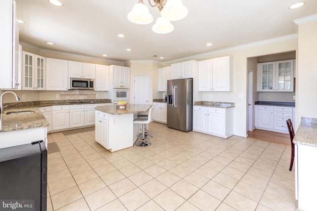 kitchen with stainless steel appliances, a sink, ornamental molding, white cabinets, and recessed lighting