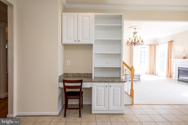 kitchen with open shelves, white cabinets, crown molding, light tile patterned flooring, and a chandelier