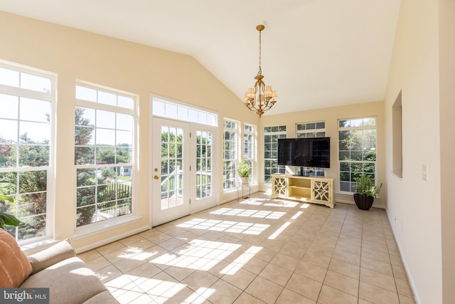 unfurnished sunroom featuring a chandelier, lofted ceiling, and french doors