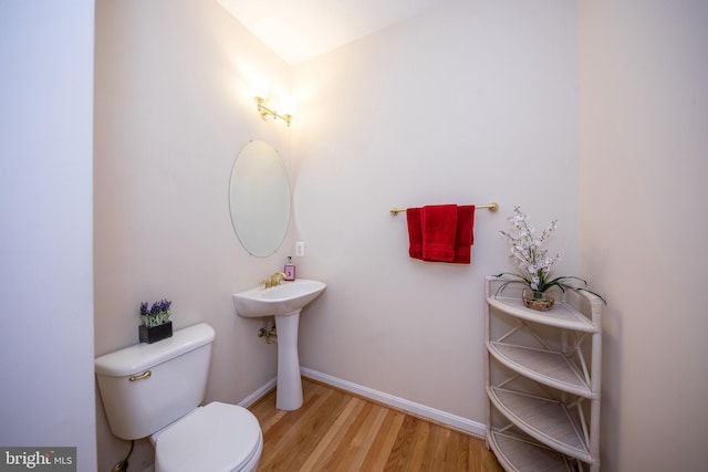 bathroom featuring wood finished floors, toilet, and baseboards