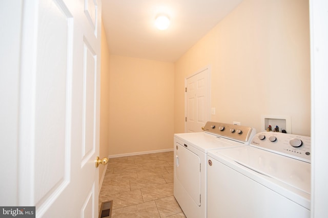 washroom with separate washer and dryer, baseboards, and light tile patterned flooring