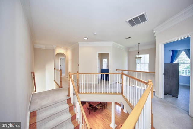 stairway with arched walkways, crown molding, baseboards, recessed lighting, and carpet