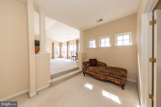 living area with decorative columns, carpet flooring, plenty of natural light, baseboards, and vaulted ceiling