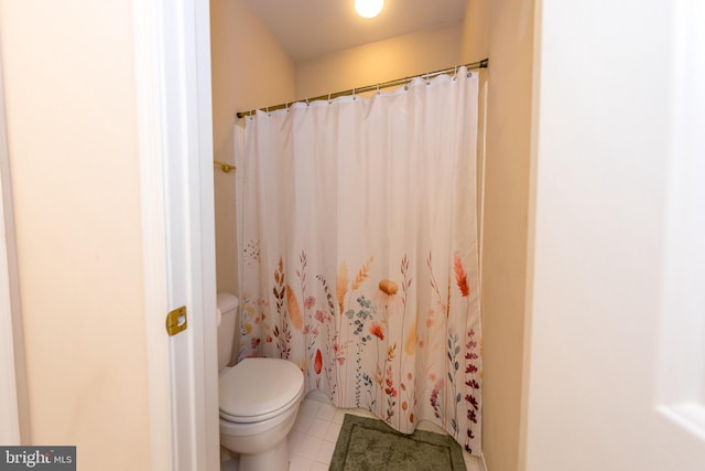 bathroom featuring toilet, tile patterned flooring, and curtained shower