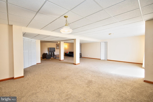 finished below grade area with carpet flooring, baseboards, and a paneled ceiling