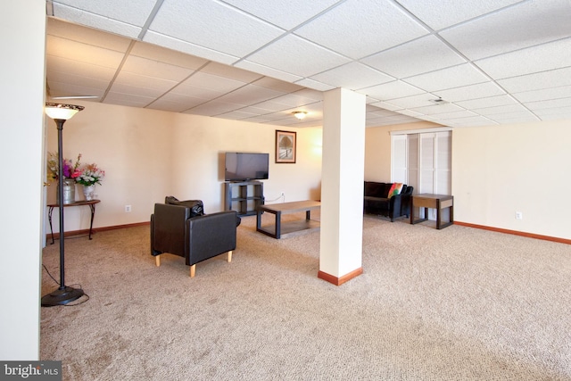 living area with carpet, a paneled ceiling, and baseboards