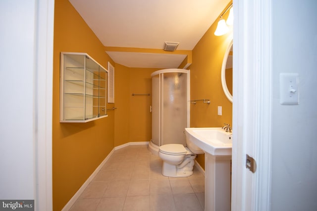 full bathroom featuring tile patterned flooring, toilet, a shower stall, baseboards, and a sink