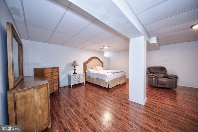 bedroom featuring a paneled ceiling, wood finished floors, and baseboards