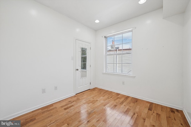 empty room featuring baseboards, light wood finished floors, and recessed lighting