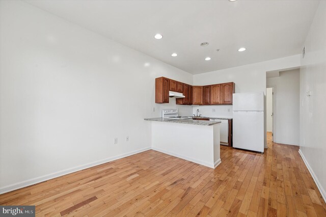 kitchen featuring a peninsula, under cabinet range hood, white appliances, light wood-style floors, and recessed lighting