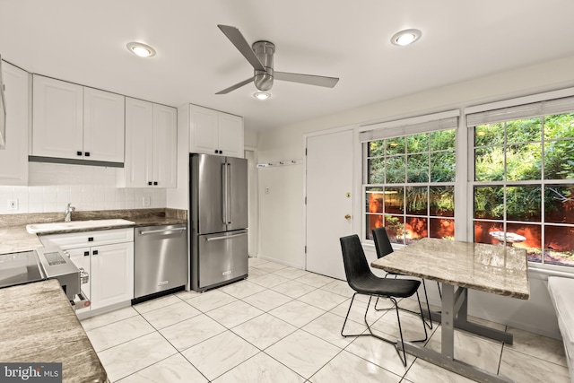 2646 S June St, Arlington, VA 22202 - kitchen featuring stainless steel appliances, a sink, ceiling fan, white cabinets, and decorative backsplash