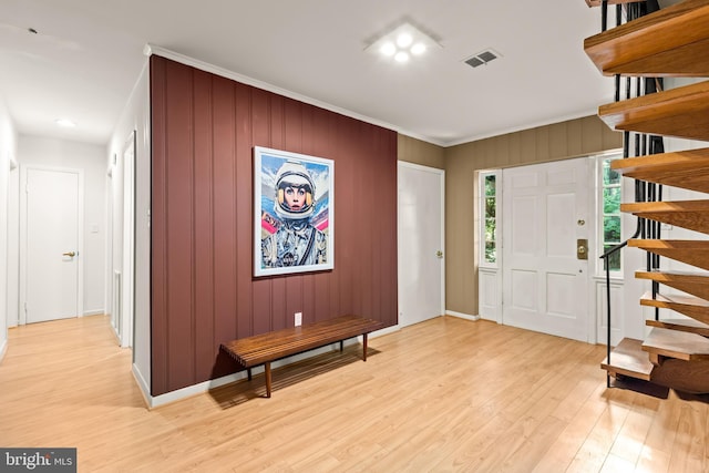 2646 S June St, Arlington, VA 22202 - foyer entrance featuring stairs, light wood-style floors, ornamental molding, baseboards, and wooden walls