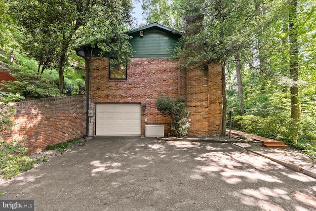 2646 S June St, Arlington, VA 22202 - view of property exterior with an attached garage, driveway, brick siding, and a chimney