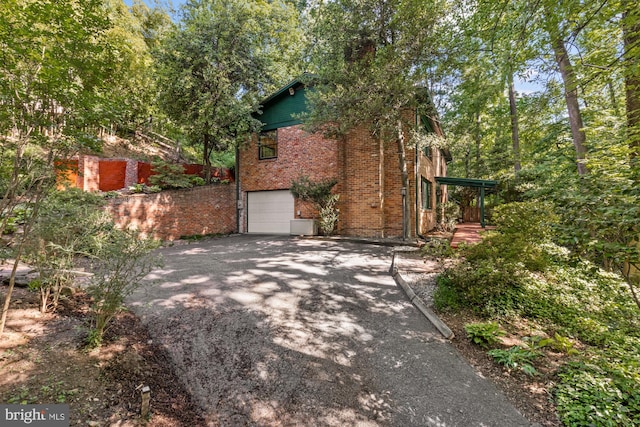 2646 S June St, Arlington, VA 22202 - view of side of home with driveway, an attached garage, and brick siding