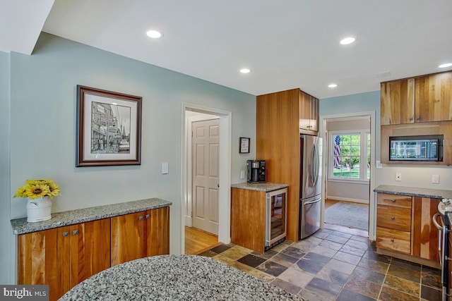 2801 Riva Rd, Annapolis, MD 21401 - kitchen featuring wine cooler, recessed lighting, stone finish floor, brown cabinets, and appliances with stainless steel finishes