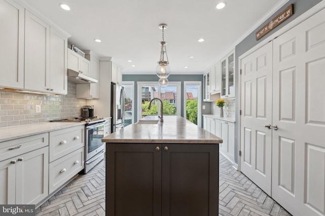 15 Chesapeake Lndg, Annapolis, MD 21403 - kitchen with stainless steel appliances, under cabinet range hood, a kitchen island with sink, tasteful backsplash, and white cabinetry