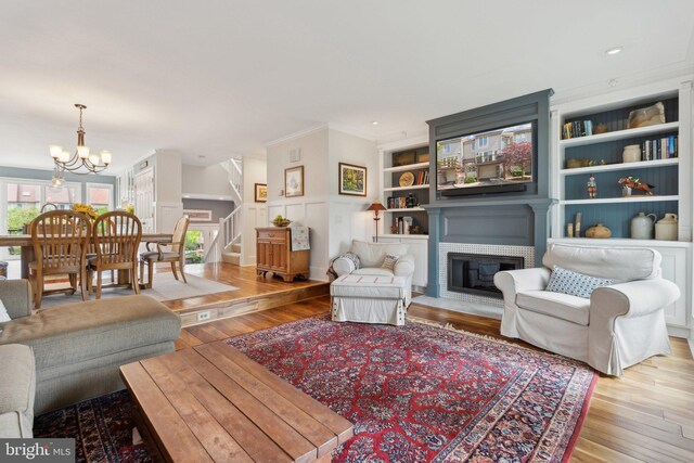 15 Chesapeake Lndg, Annapolis, MD 21403 - living room featuring stairs, wood finished floors, a brick fireplace, built in shelves, and a chandelier