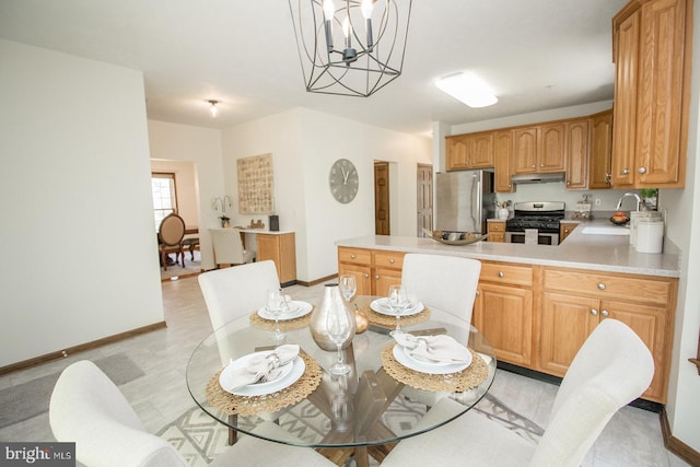 dining space featuring a notable chandelier and baseboards