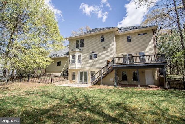 rear view of property featuring a fenced backyard, a lawn, stairway, a patio, and a deck