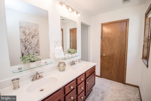 bathroom featuring a sink, visible vents, baseboards, and double vanity