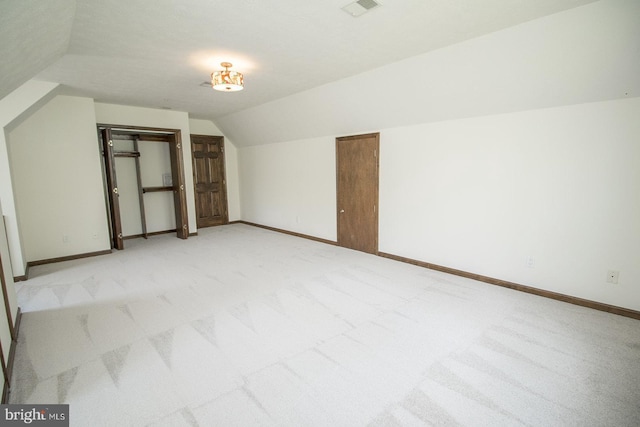 bonus room with light colored carpet, baseboards, and lofted ceiling