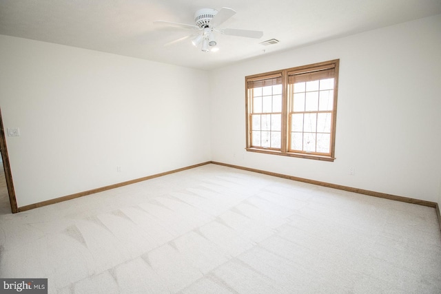 empty room with light carpet, baseboards, a ceiling fan, and visible vents