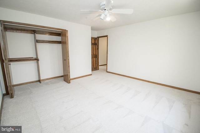 unfurnished bedroom featuring light carpet, baseboards, a closet, and ceiling fan