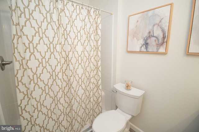 bathroom with curtained shower and toilet