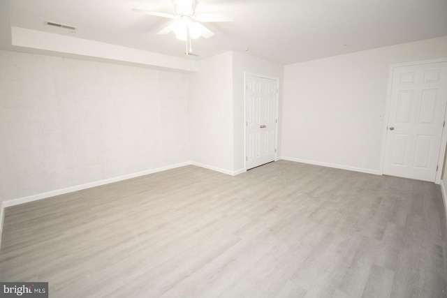 empty room with visible vents, baseboards, a ceiling fan, and wood finished floors