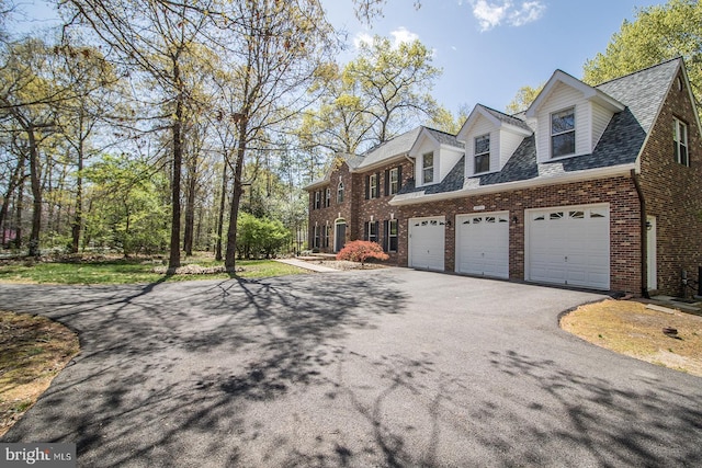 view of property exterior with roof with shingles, aphalt driveway, a garage, and brick siding