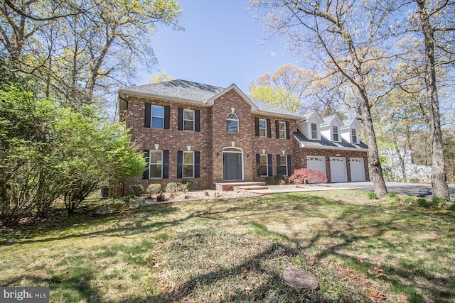 view of front of home with aphalt driveway, a garage, a front lawn, and brick siding
