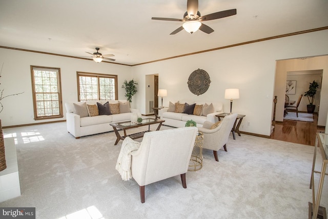 carpeted living area featuring baseboards, crown molding, and ceiling fan