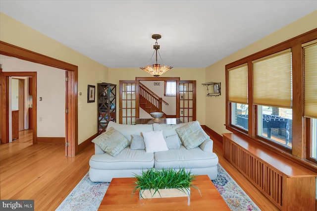 157 Hartswick Ave, State College, PA 16803 - living area featuring a notable chandelier, radiator heating unit, light wood-type flooring, and baseboards