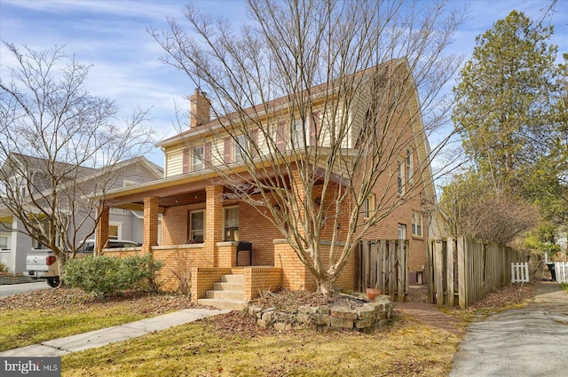 157 Hartswick Ave, State College, PA 16803 - view of front of home with brick siding, a porch, a chimney, and fence